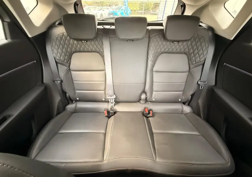 Vue arrière de l'intérieur du Renault Captur 2021, montrant la banquette arrière en cuir noir avec surpiqûres losangées.