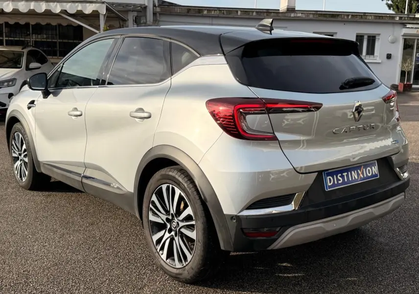 Vue 3/4 arrière droite du Renault Captur gris Highland 2021 avec toit noir et jantes alliage distinctives.