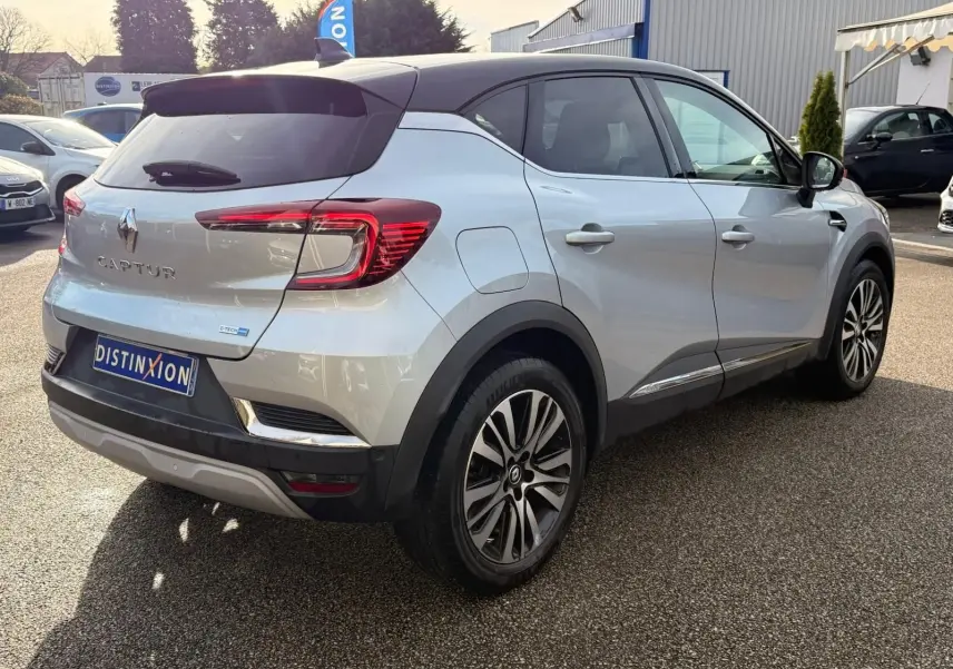 Vue 3/4 arrière droite d'un Renault Captur gris Highland avec toit noir et feux arrière LED distinctifs.