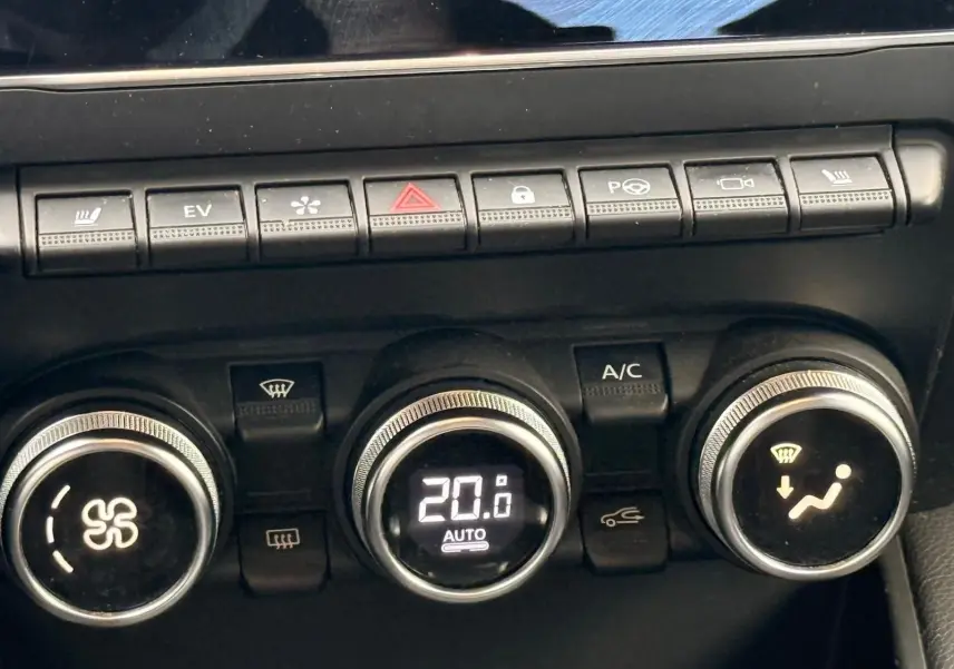 Gros plan sur la console de climatisation du Renault Captur gris Highland, affichant 20°C en mode automatique.