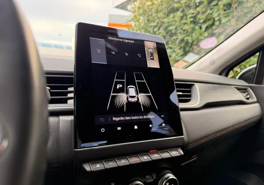 Écran tactile central du Renault Captur gris Highland 2021 montrant l'aide au stationnement avec vue 360° intérieure.