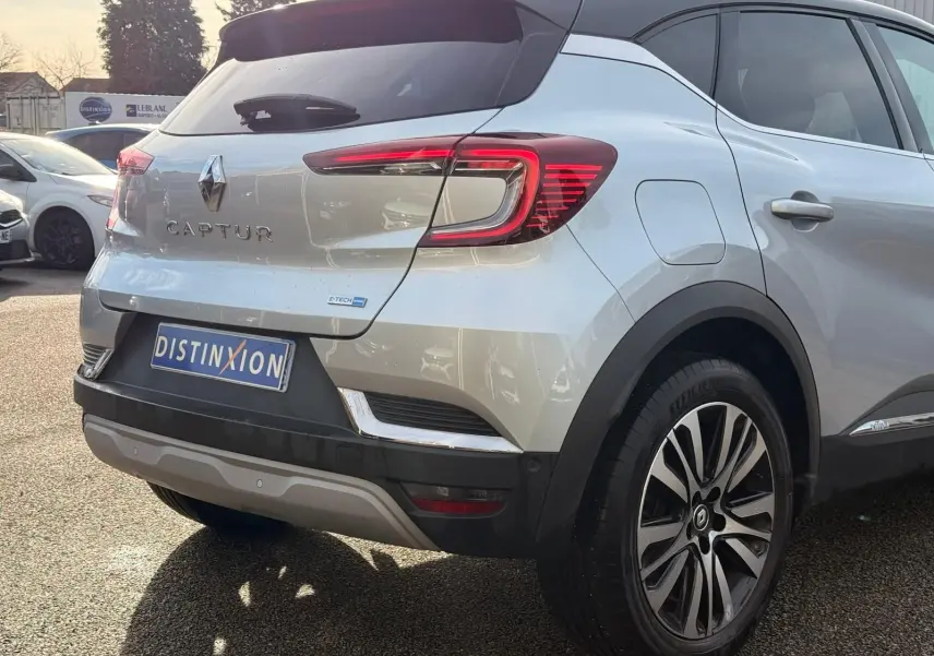 Vue 3/4 arrière droite d'un Renault Captur gris Highland avec feux LED et jantes alliage distinctives.