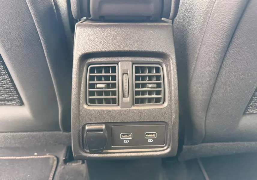 Prise USB double et sortie 12V sous les aérateurs arrière du Renault Captur gris Highland 2021, vue centrée depuis l'arrière.