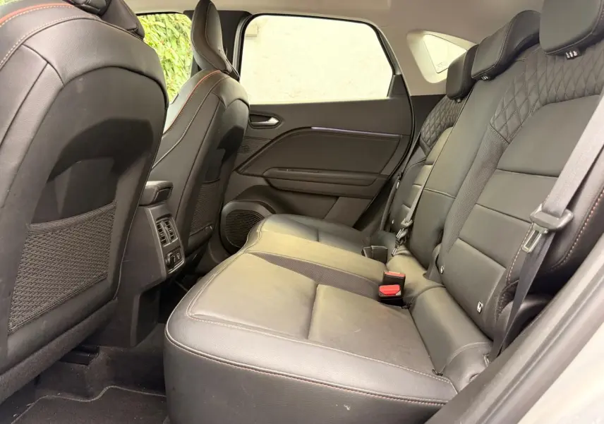 Vue intérieure côté droit des sièges arrière en cuir noir du Renault Captur hybride 2021, soulignant les finitions soignées.