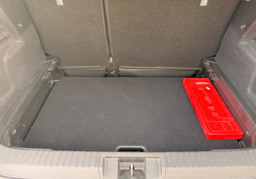 Coffre ouvert d’un Renault Captur gris Highland 2021, vue intérieure avec boîte à outils rouge à droite.