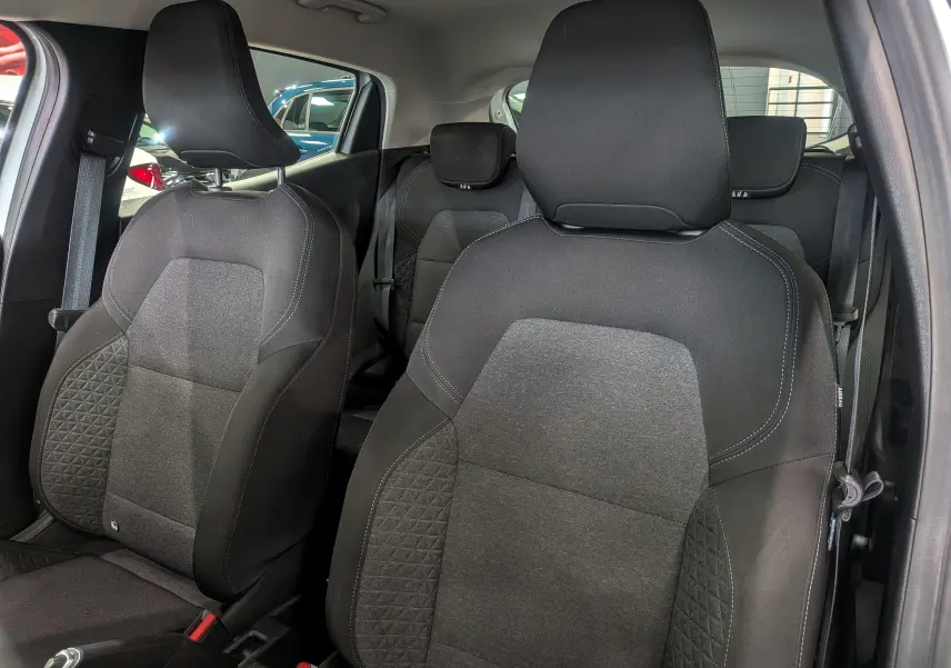 Vue intérieure rapprochée des sièges avant en tissu gris foncé de la Renault Clio V Business 2020 Blanc Glacier.