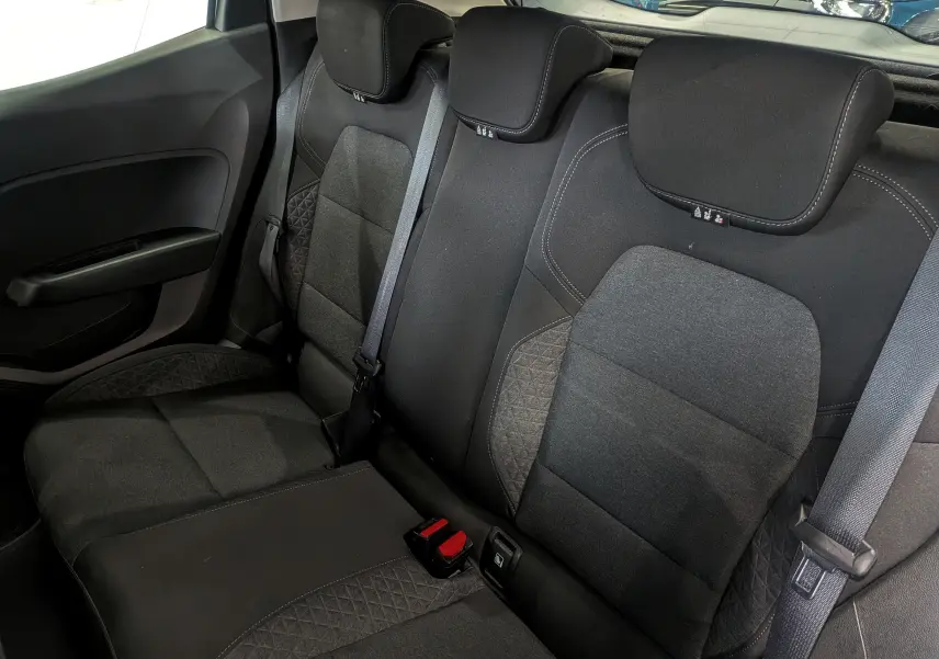 Vue intérieure des sièges arrière en tissu noir de la Renault Clio V Business, avec ceintures de sécurité visibles.