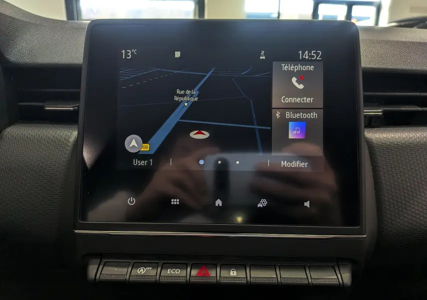 Écran tactile central du tableau de bord de la Renault Clio V Business 2020 affichant la navigation et les options Bluetooth.