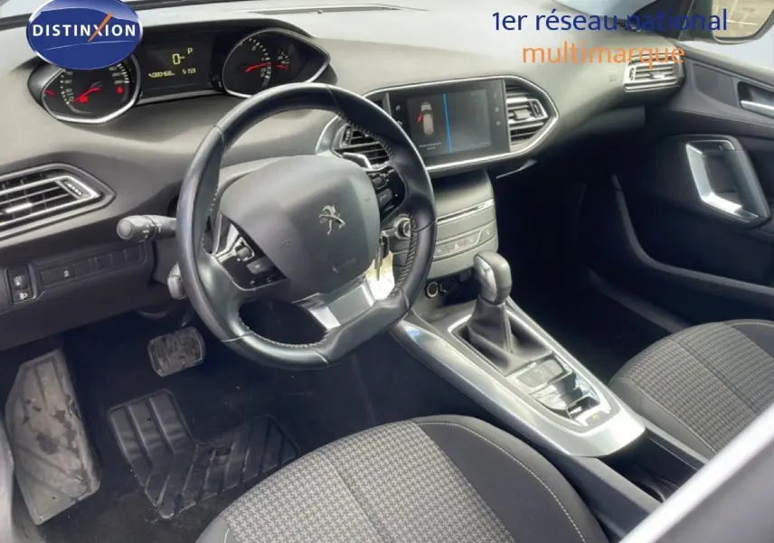 Intérieur avant droit de la Peugeot 308 SW 2019 noir Perla Nera, volant cuir, tableau de bord avec écran tactile et boîte auto.
