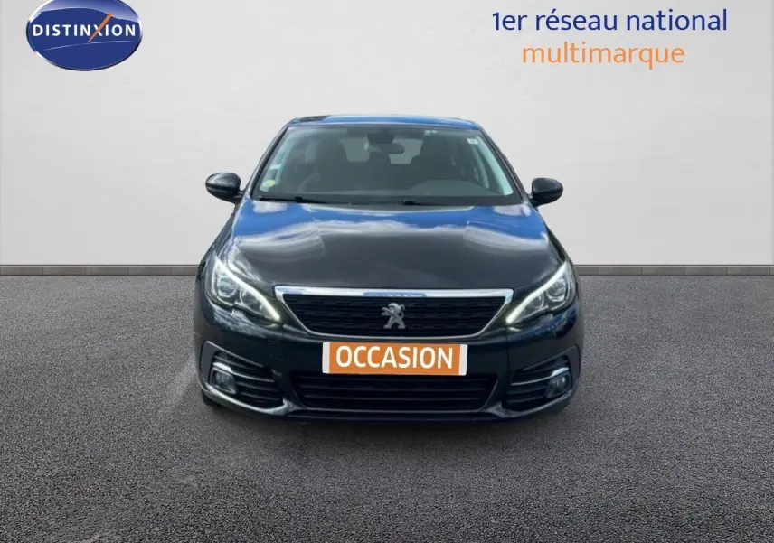 Vue frontale d'une Peugeot 308 SW noire Perla Nera Metal avec calandre chromée et phares LED allumés.