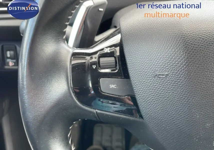 Gros plan sur le volant cuir noir de la Peugeot 308 SW 2019 avec commandes audio intégrées côté gauche.