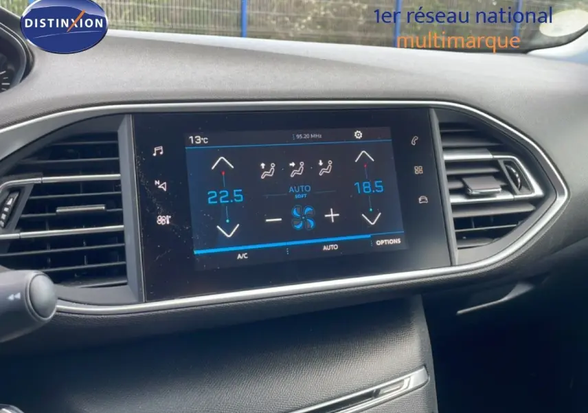 Vue rapprochée de l’écran tactile central du tableau de bord de la Peugeot 308 SW noir Perla Nera, affichant la climatisation automatique.