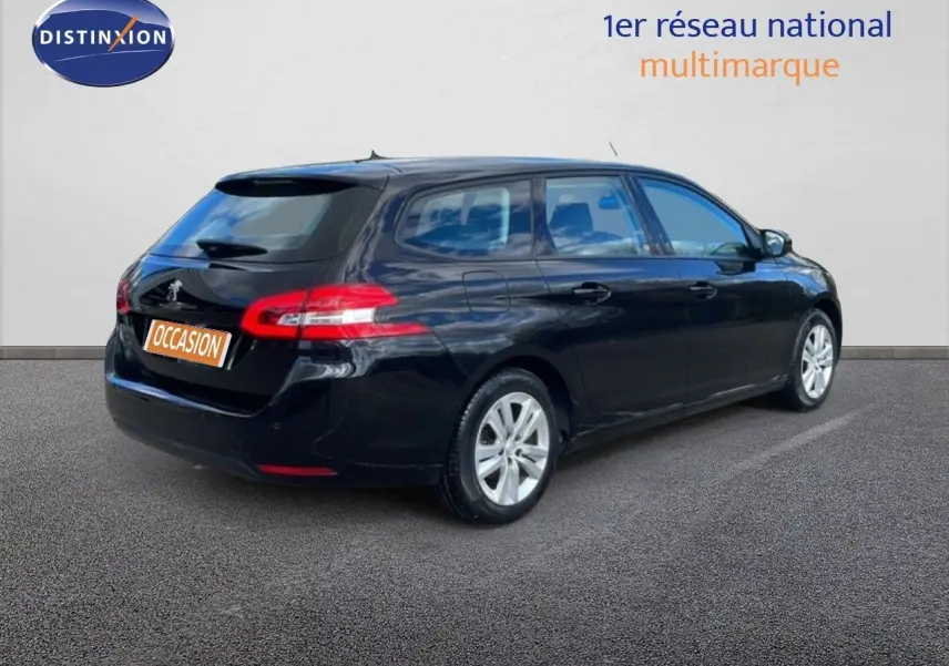 Peugeot 308 SW noire vue 3/4 arrière côté droit, avec feux arrière allongés et jantes argentées.