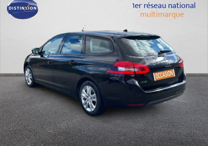 Peugeot 308 SW noir perla nera, vue 3/4 arrière droit, avec feux arrière allongés et jantes argentées.
