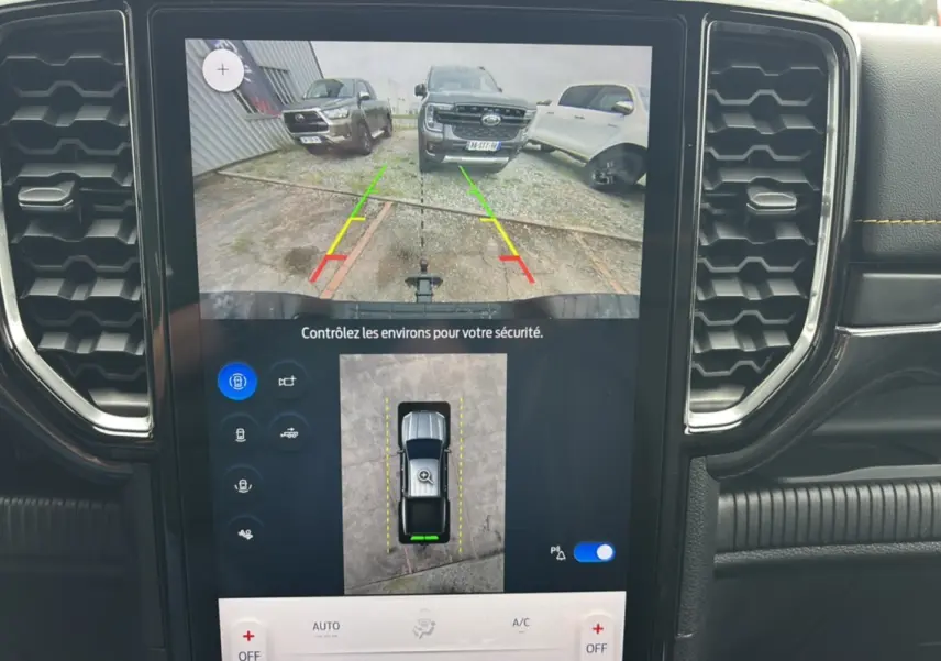 Écran central montrant la caméra de recul du Ford Ranger noir agate, avec vue arrière et lignes de guidage colorées.