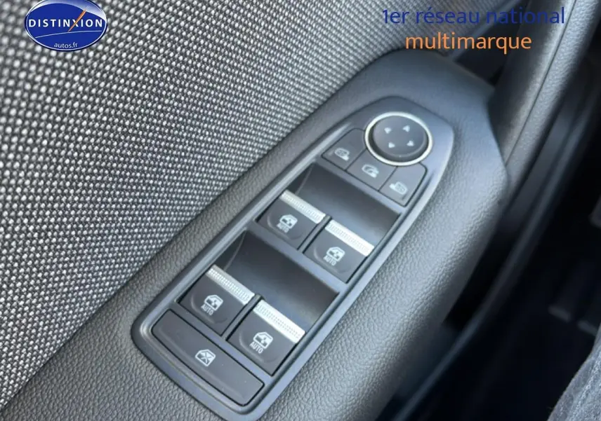 Gros plan sur les commandes des vitres électriques côté gauche d'une Renault Captur bleu iron toit noir.