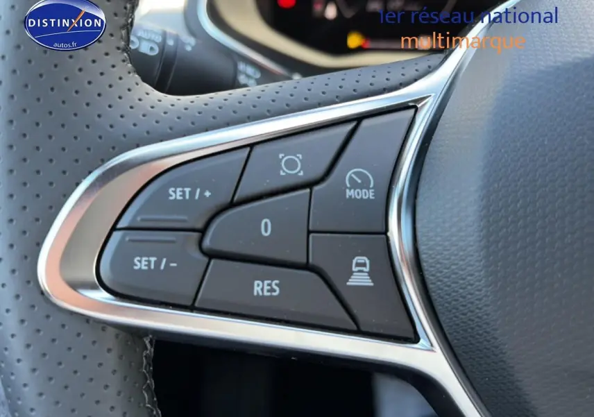 Gros plan sur les commandes multifonctions à gauche du volant perforé du Renault Captur bleu iron 2026.