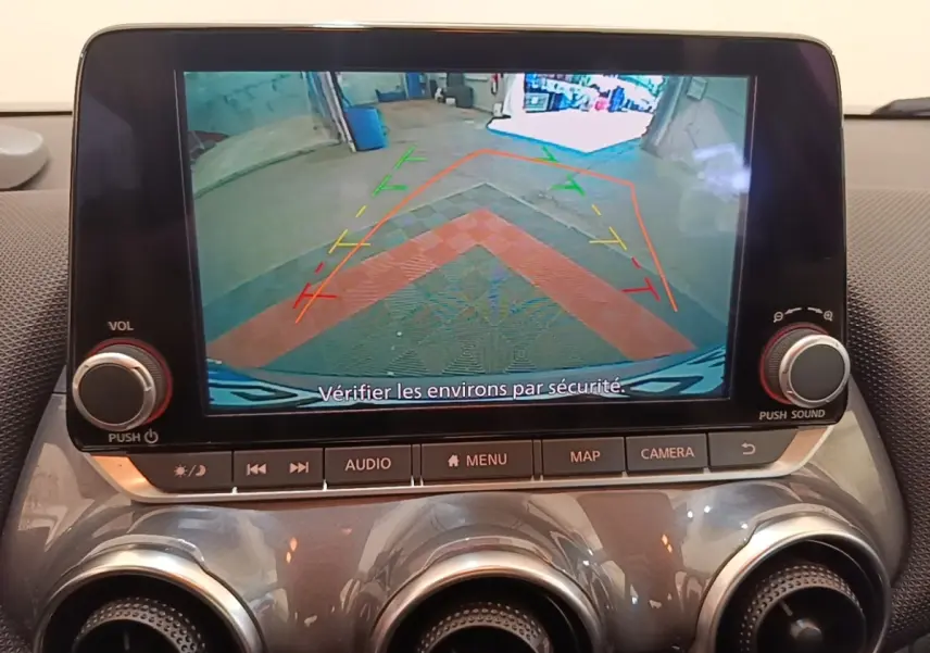 Écran tactile central montrant la caméra de recul avec lignes de guidage, intérieur gris clair du Nissan Juke 2023.