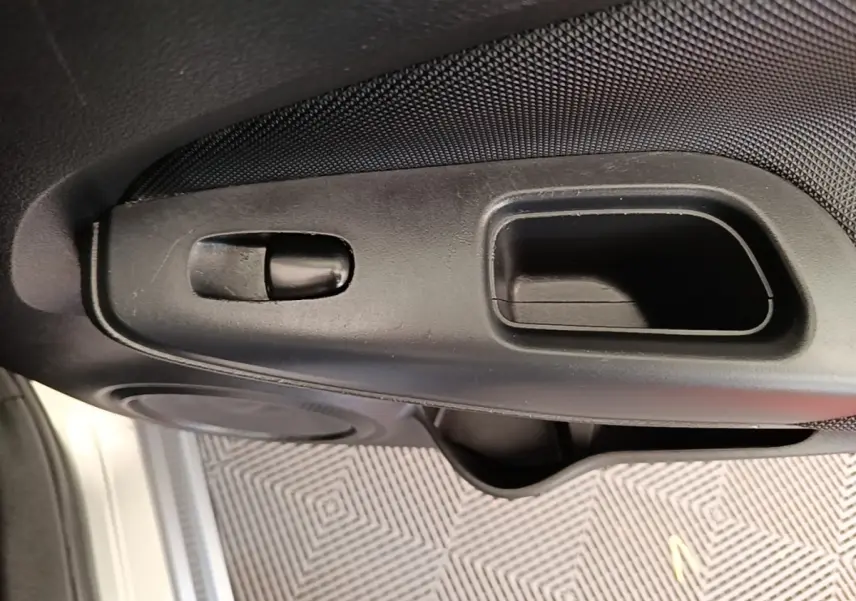 Détail de la poignée intérieure de porte côté conducteur du Nissan Juke gris clair 2023, finition Business Edition.