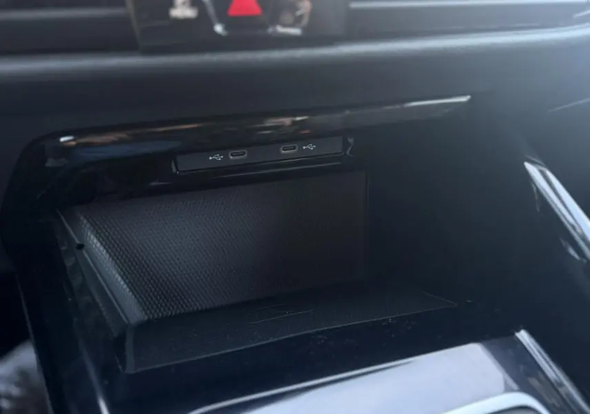Gros plan sur le compartiment de rangement noir brillant avec ports USB-C dans une Volkswagen Golf VIII 1.5 TSI 130 Style 2024.