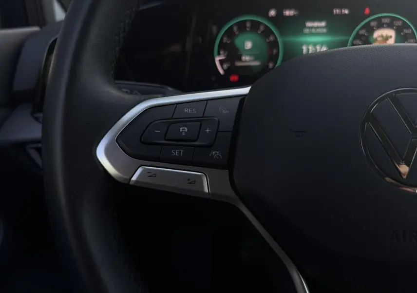 Gros plan sur le volant multifonction noir de la Volkswagen Golf VIII 2024 avec commandes de régulateur adaptatif.