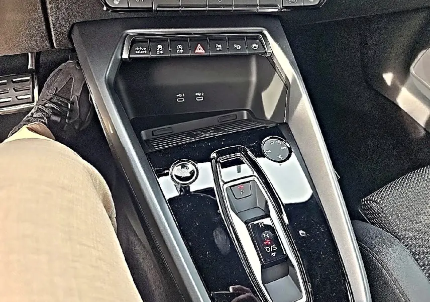 Vue plongeante sur la console centrale noire brillante avec levier de vitesses automatique et commandes Audi A3 Sportback 2026.