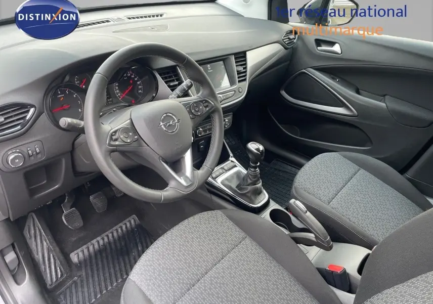 Vue intérieure côté conducteur de l'Opel Crossland 2022 avec tableau de bord noir et sièges tissu gris.
