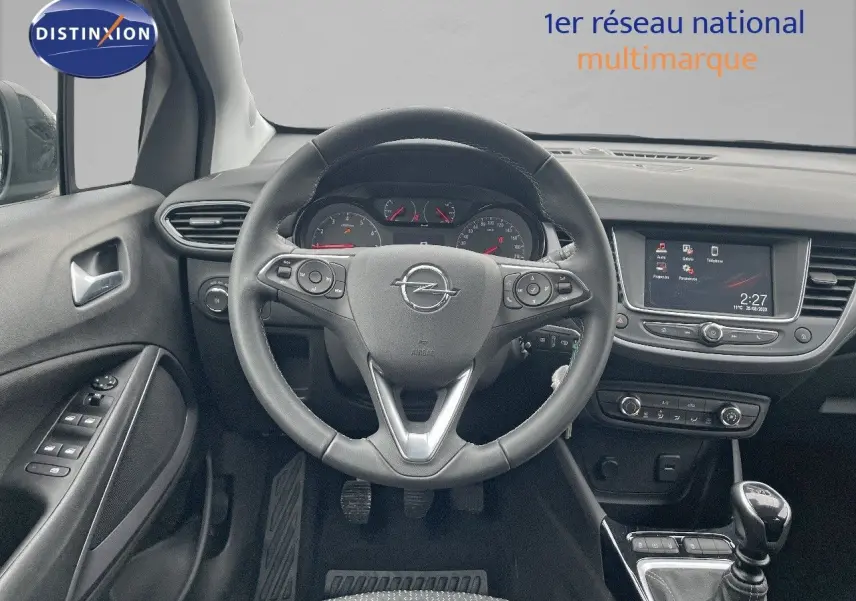 Vue intérieure centrée sur le volant et tableau de bord de l'Opel Crossland gris minéral, avec écran tactile et boîte manuelle.