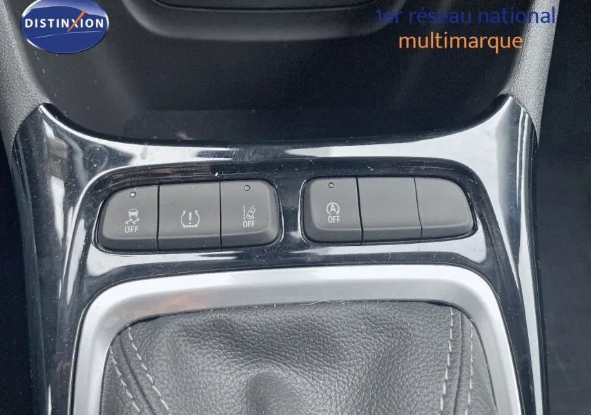 Gros plan sur la console centrale de l'Opel Crossland gris minéral, montrant les boutons de contrôle et le soufflet de levier de vitesses.