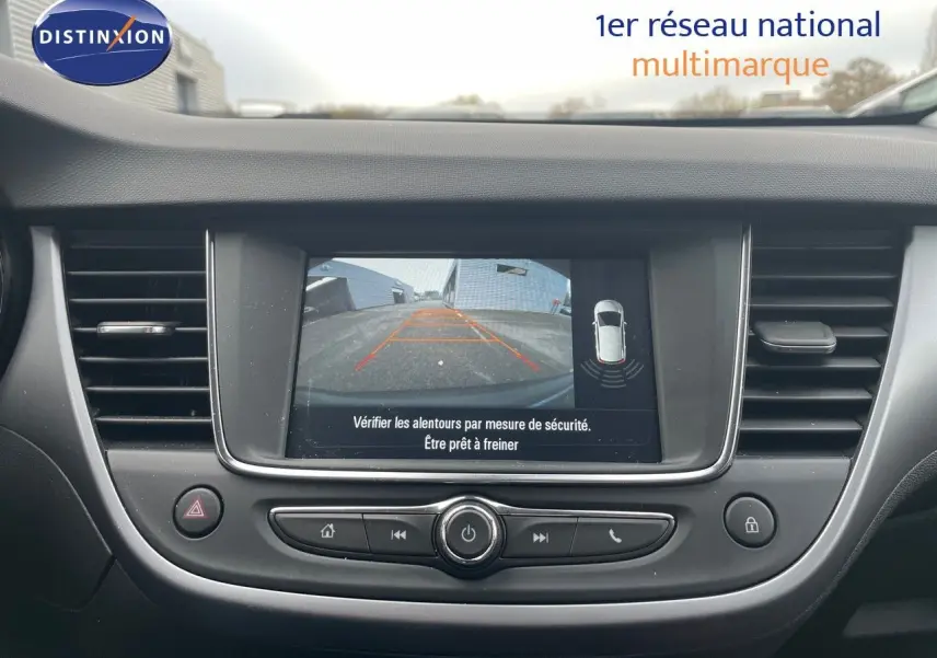 Tableau de bord de l'Opel Crossland 2022 avec écran tactile affichant la caméra de recul et commandes intégrées.