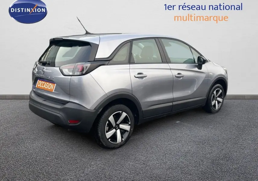 Opel Crossland gris minéral métal vu de trois quarts arrière droit, avec toit noir et jantes distinctives.