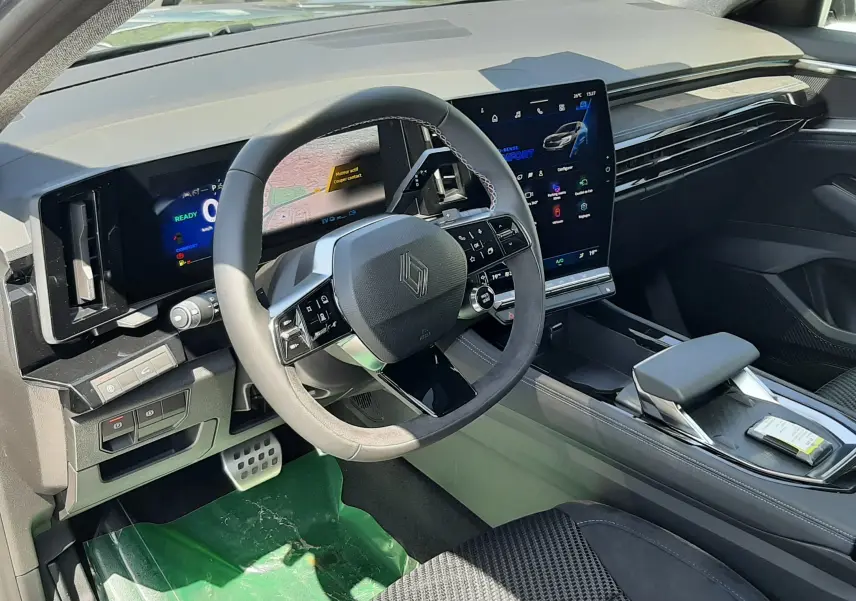 Vue intérieure côté conducteur du tableau de bord et volant noir du Renault Espace VI gris schiste métal avec écran tactile central.