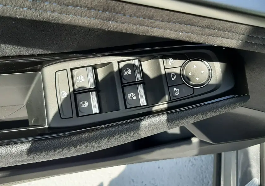 Gros plan sur les commandes des vitres et rétroviseurs côté gauche d'une Renault Espace gris schiste 2025.