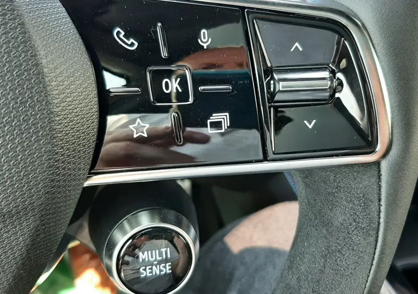 Gros plan sur les commandes gauche du volant en cuir noir et alcantara du Renault Espace VI gris schiste, avec bouton Multi Sense.