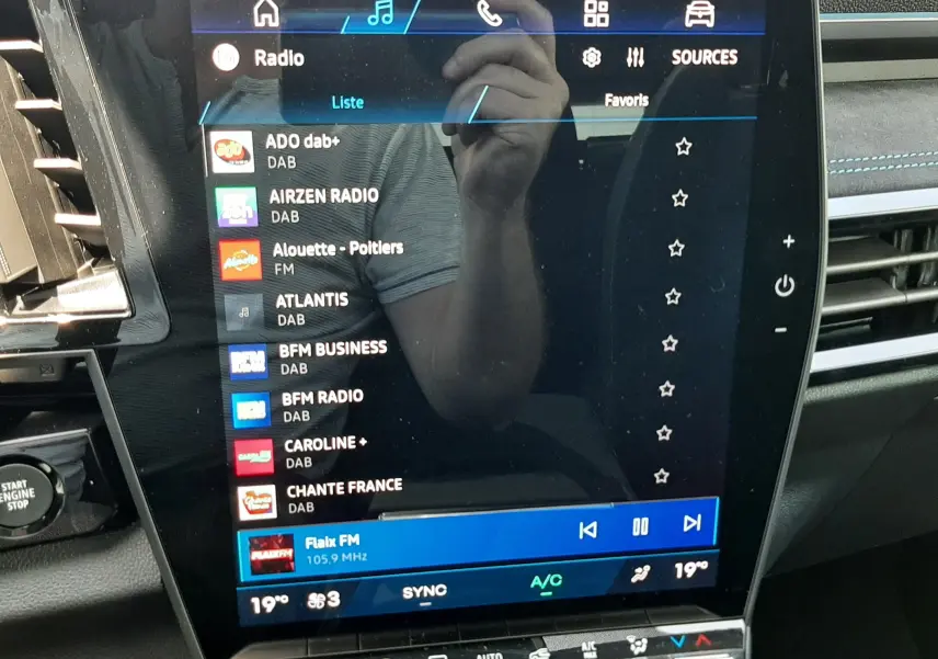 Écran tactile central de la Renault Espace VI gris schiste, affichant la liste des radios DAB et FM, intérieur moderne.