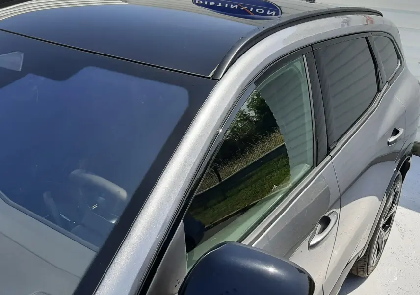 Vue 3/4 avant droit du Renault Espace VI gris schiste métal avec toit panoramique noir et vitres teintées.