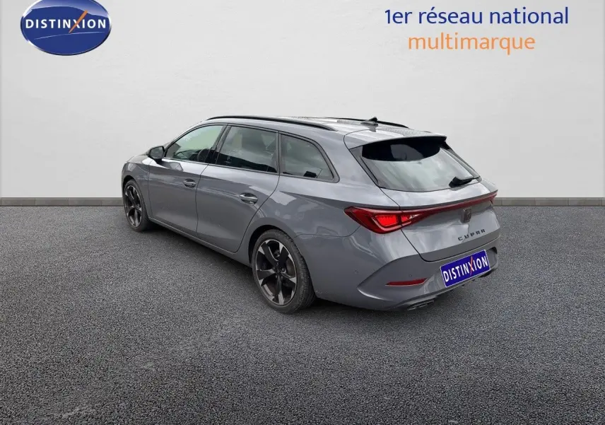 Vue 3/4 arrière droite d'une CUPRA LEON ST gris Graphene Metal avec jantes bi-ton et feux arrière LED distinctifs.