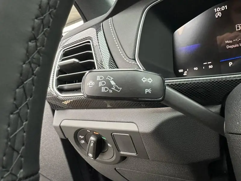 Détail intérieur côté gauche du Volkswagen T-Cross 2025 gris Ascot, montrant la commande des phares et le levier de clignotants.