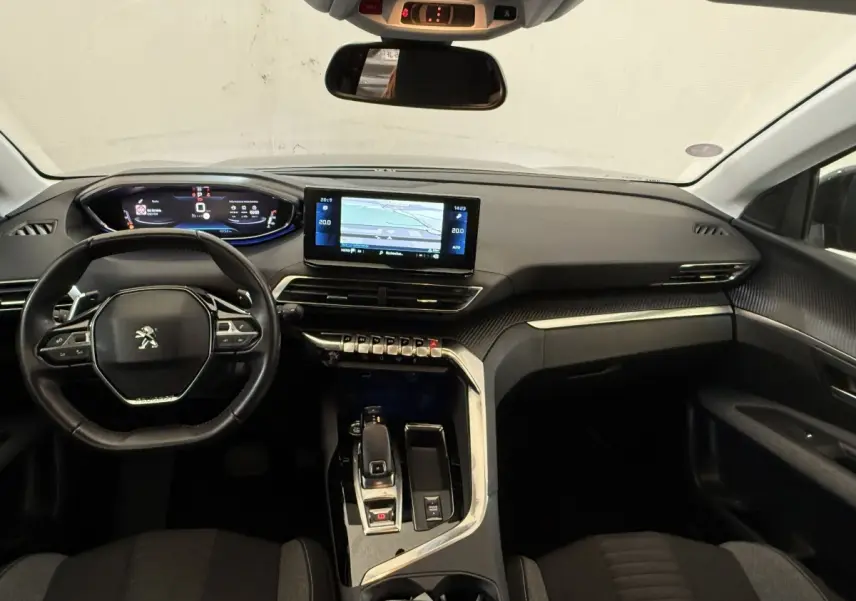 Vue intérieure avant du Peugeot 3008 bleu 2021, tableau de bord moderne avec écran tactile et volant cuir multifonctions.