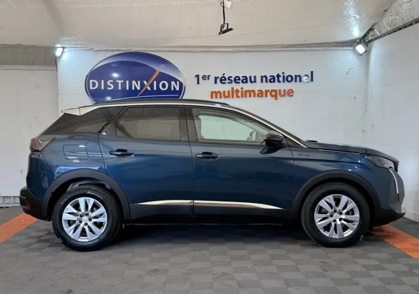 Vue latérale droite d’un Peugeot 3008 bleu 2021 version Style avec jantes alliage et rails de toit assortis.