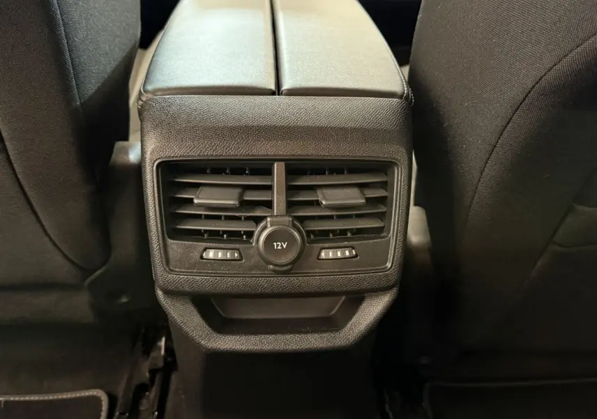 Vue rapprochée des aérateurs arrière et prise 12V entre les sièges noirs du Peugeot 3008 bleu 2021.