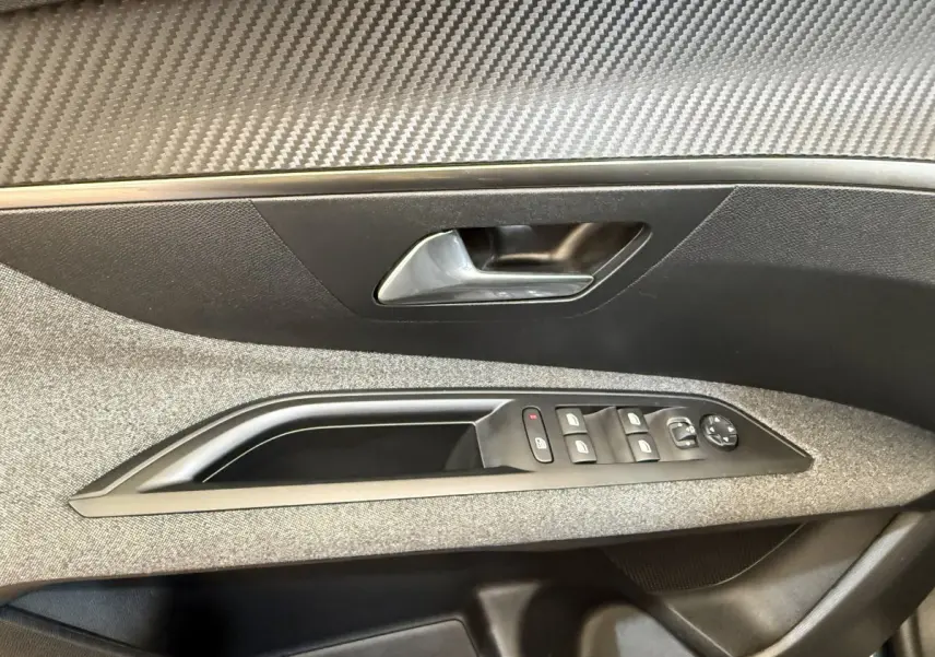 Gros plan sur la porte intérieure côté conducteur du Peugeot 3008 bleu, avec commandes de vitres et poignée argentée.