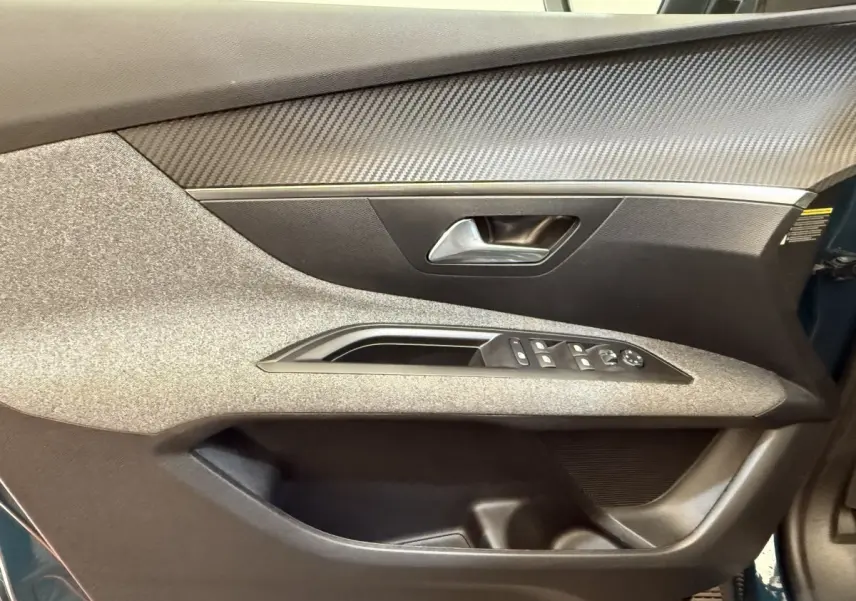 Vue rapprochée de la porte avant gauche du Peugeot 3008 bleu, avec commandes électriques et habillage texturé gris.