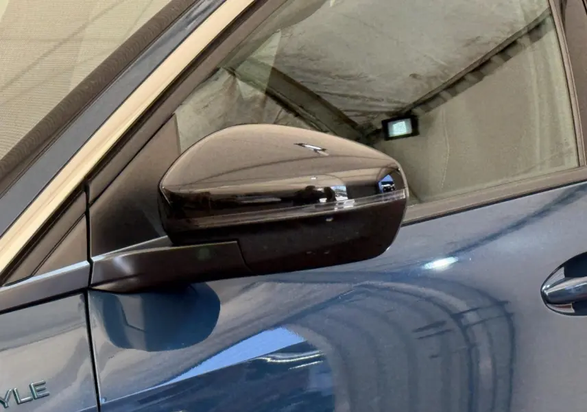 Rétroviseur droit noir brillant sur Peugeot 3008 bleu, vue rapprochée du côté conducteur avec poignée de porte visible.