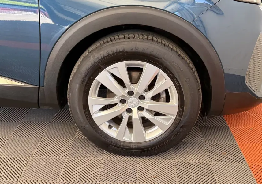 Gros plan sur la roue avant gauche du Peugeot 3008 bleu 2021 avec jante alliage et pneu Michelin.
