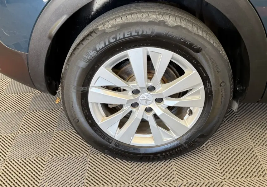 Gros plan sur la roue avant droite du Peugeot 3008 bleu, avec jante alliage argent et pneu Michelin.