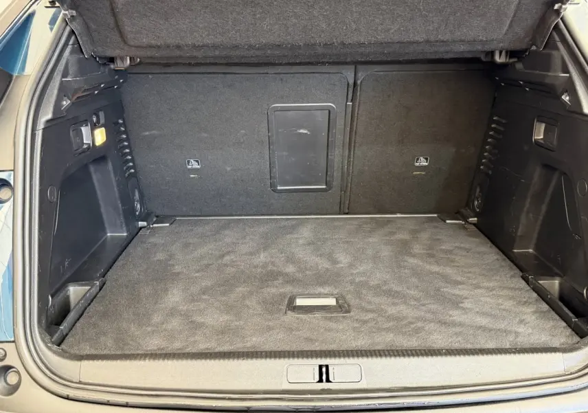 Coffre ouvert du Peugeot 3008 bleu, vue intérieure arrière montrant un espace de chargement propre et bien agencé.