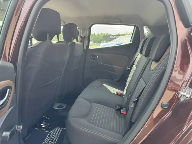 Vue intérieure arrière droite de la Renault Clio IV marron, montrant les sièges arrière en tissu noir avec ceintures de sécurité.