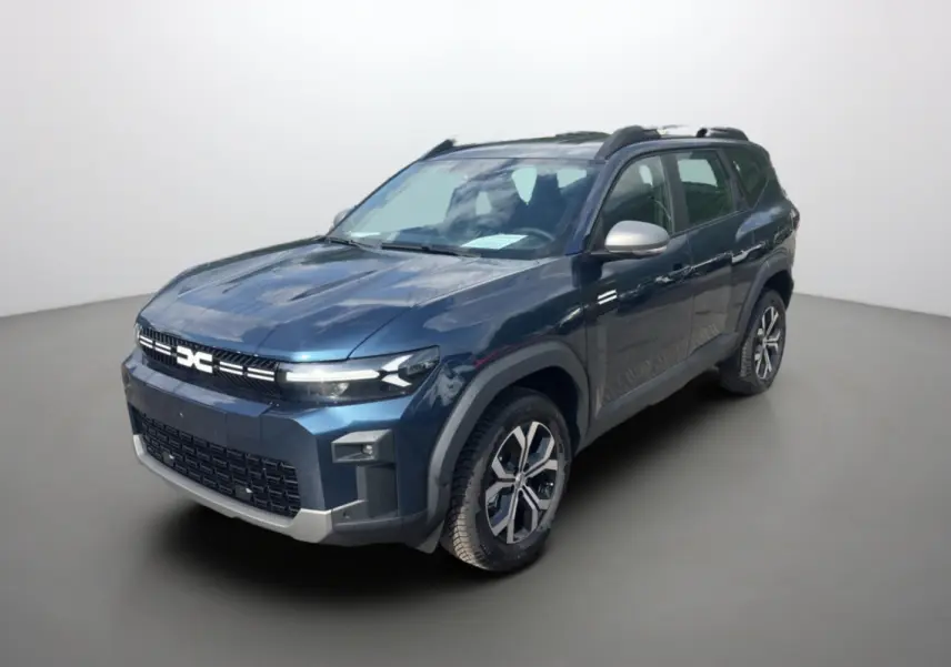 SUV Dacia Bigster bleu indigo en 3/4 avant droit, avec barres de toit et jantes alu 17 pouces visibles.