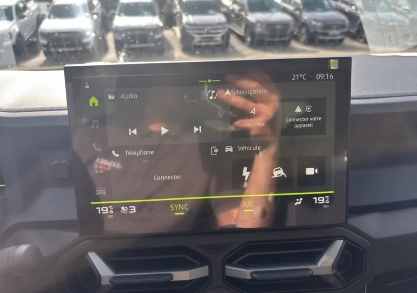 Écran tactile central du tableau de bord du Dacia Bigster Hybrid-G 150, affichant navigation et climatisation.